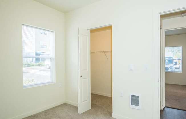 an empty bedroom with a closet and a window