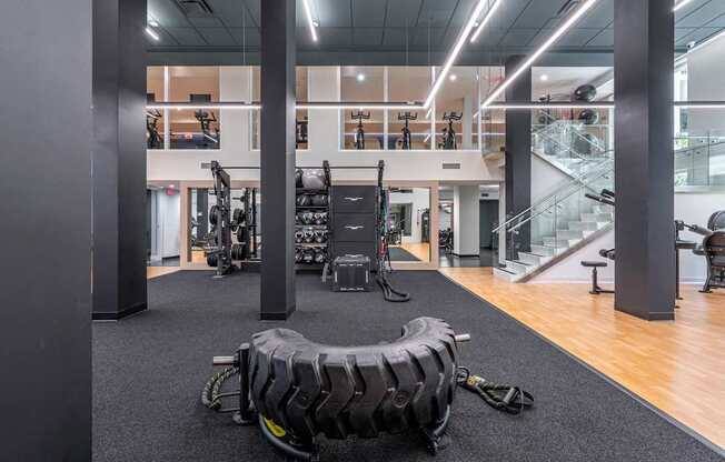 A gym with a variety of equipment including a tire flipping station.