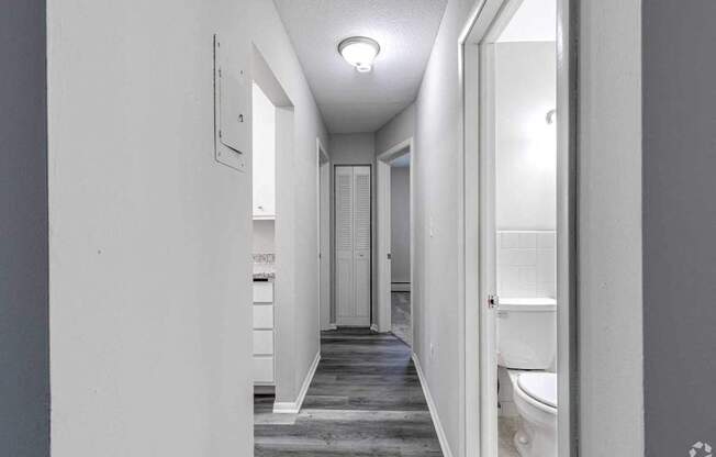 A long white hallway with a door on the right.