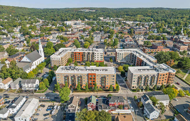 an aerial view of a city with buildings and trees at The Merc, Massachusetts, 02453