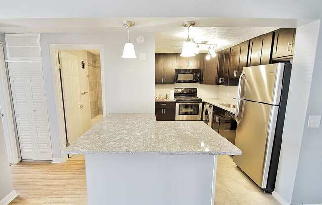 A kitchen with a granite countertop and stainless steel appliances.