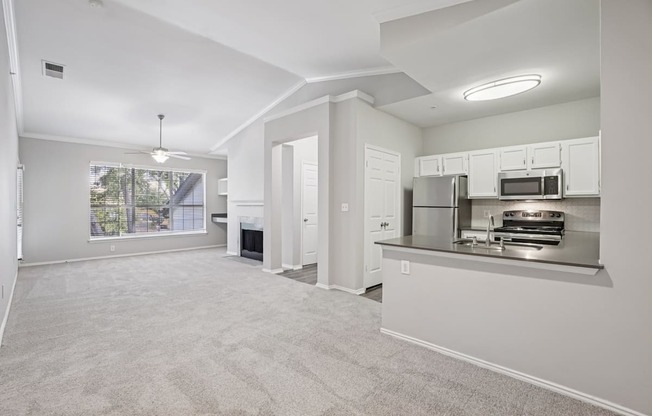 A spacious living area with a kitchenette and a fireplace.