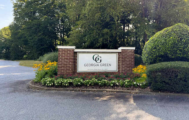 A sign that says "Georgia Green" is surrounded by flowers and greenery.