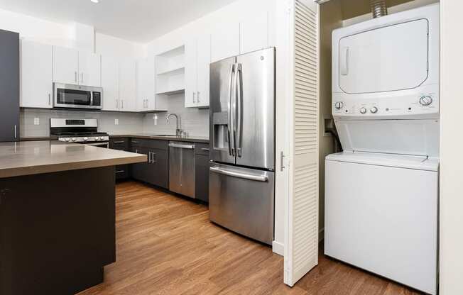 White stackable washer and dryer, kitchen with stainless appliances