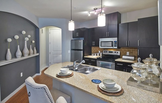 a kitchen with black cabinets and a granite counter top at Mockingbird Flats, Dallas