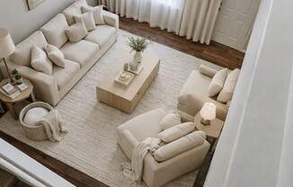 A living room with a white couch and a rug.