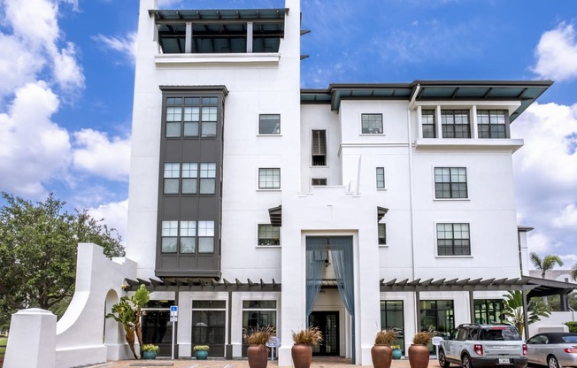 a large white building with cars parked in front of it at Azul Baldwin Park, Florida