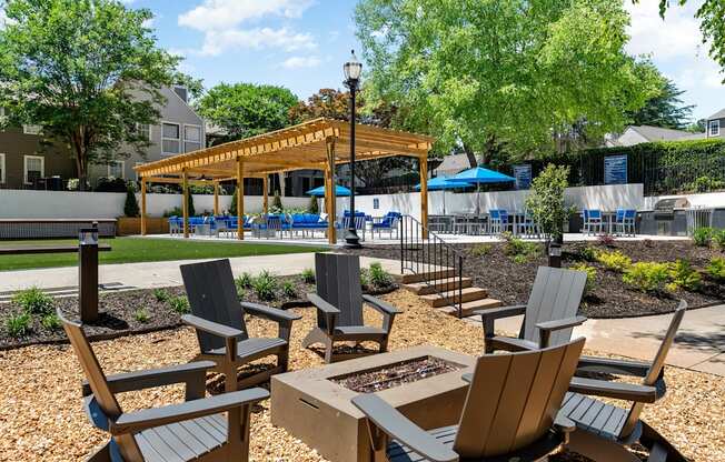 A wooden gazebo is surrounded by chairs and tables in a park.