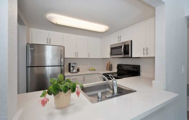 a kitchen with white counter tops and a stainless steel refrigerator at Rush River Apartments, Sacramento, CA, 95831