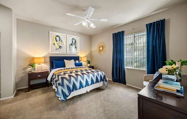 A bedroom with a bed, nightstands, and a ceiling fan.at The Equestrian by Picerne, Henderson Nevada
