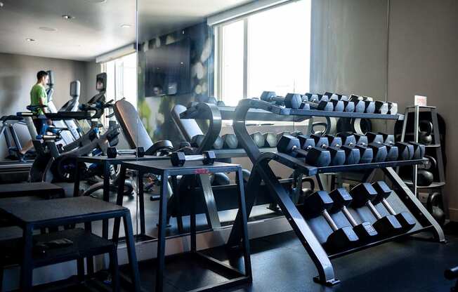 A gym with a variety of equipment including treadmills, weights, and exercise machines.