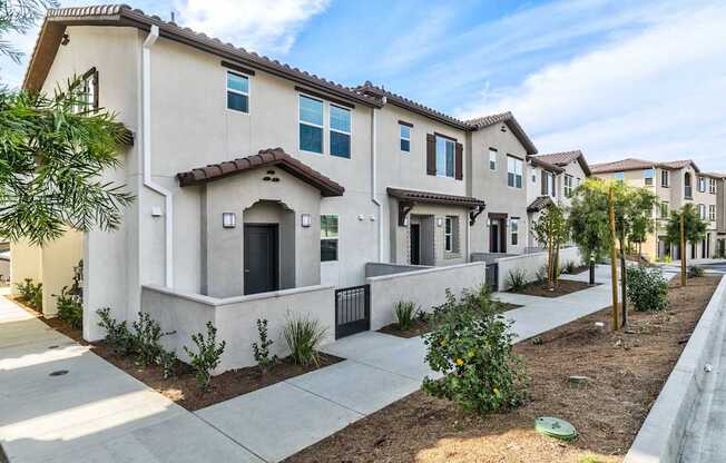 A row of modern houses with a clear blue sky above them.