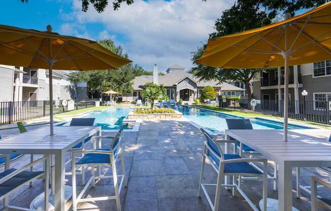 A pool surrounded by chairs and umbrellas.