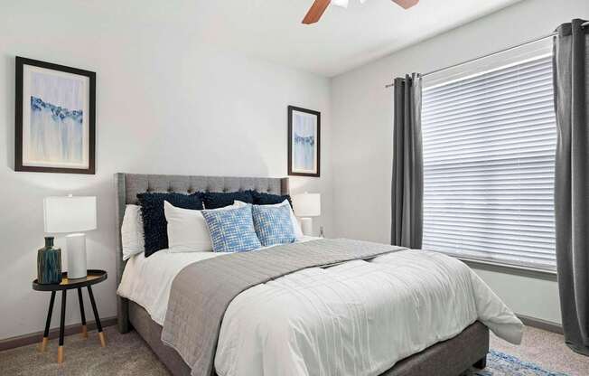 A bedroom with a large bed and two framed pictures on the wall.