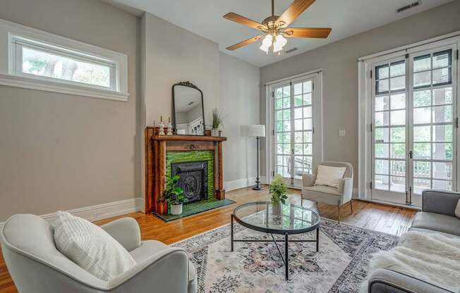A living room with a fireplace and a ceiling fan.