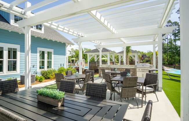 a patio with tables and chairs under a white roof