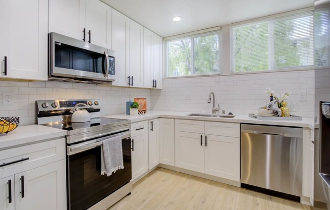 a kitchen with white cabinets and stainless steel appliances