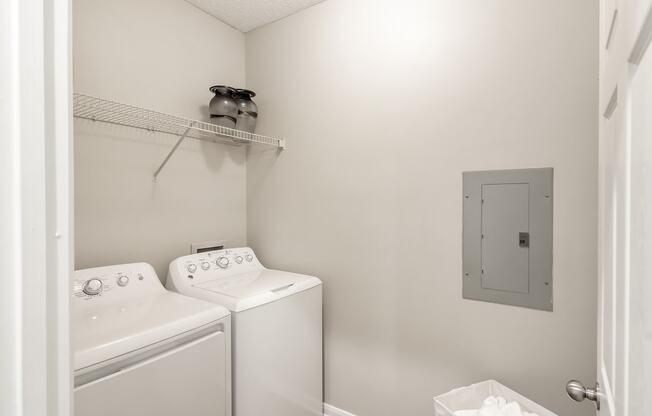 a white washer and dryer in a white laundry room at Lagniappe of Biloxi Apartment Homes, Biloxi