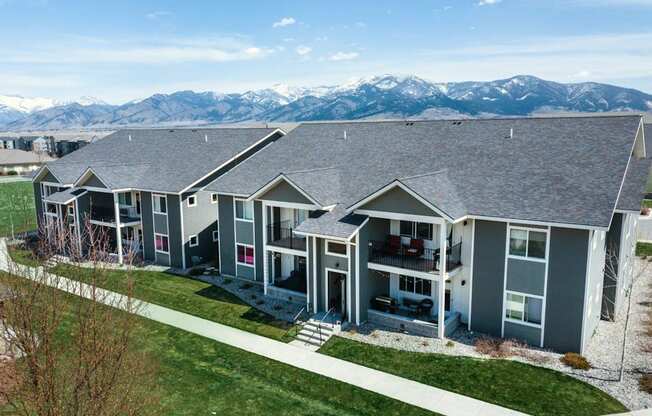 an aerial view of three houses with mountains in the background at Madison Park, Montana, 59718