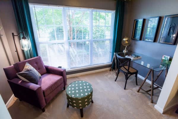 A living room with a purple chair and ottoman.
