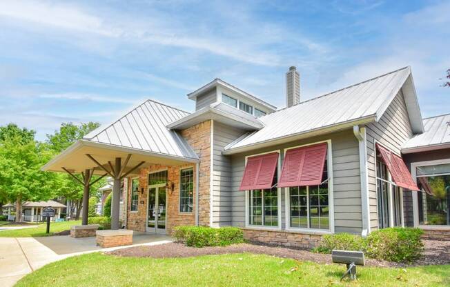 A modern house with a grey exterior and a red awning.