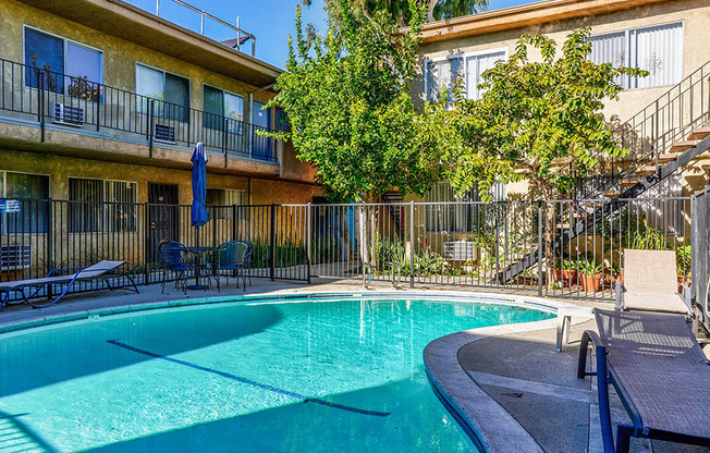 View of gated community pool with lounging space.