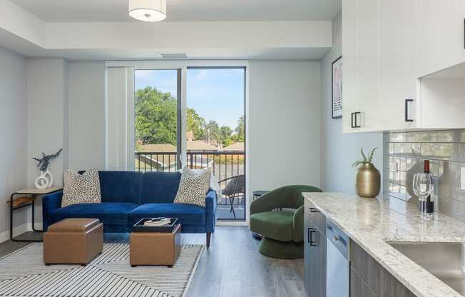 a living room with a blue couch and a kitchen counter