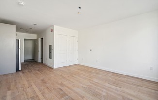 an empty living room with white walls and wood floors