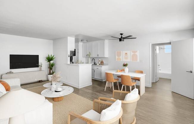 A modern living room with a white sofa, a coffee table, and a dining table set up.