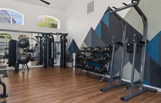 A gym with a variety of equipment including weights and machines.
