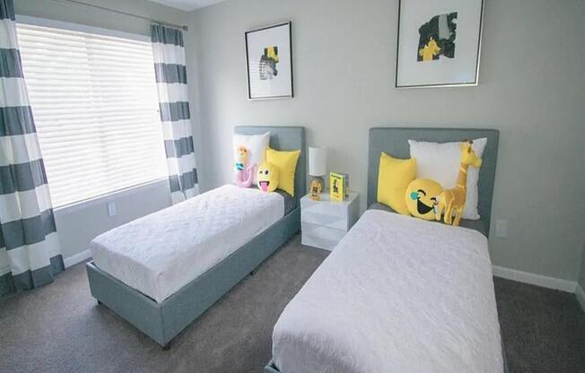 two twin beds in a bedroom and yellow pillows at The Sapphire, Decatur, Georgia