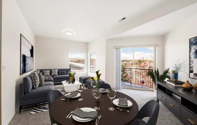 a dining area with a round table and chairs and a living room with a couch and wall art. at Shoreline Village, Richland Washington