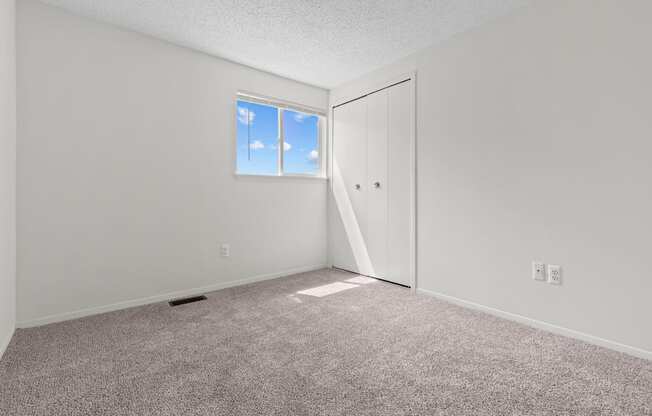 an empty room with carpet and a window