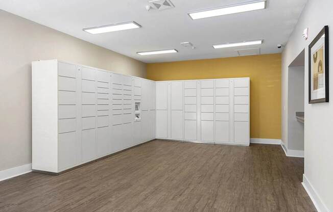 A room with a yellow wall and a white filing cabinet.