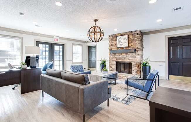 A living room with a grey couch and a fireplace.