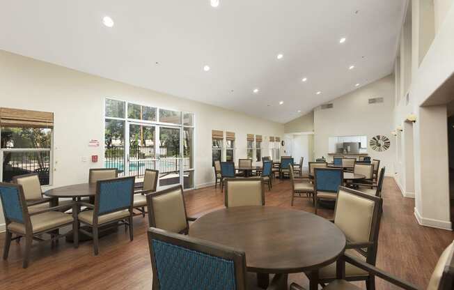 Clubhouse Lounge sitting area with a couch, three chairs, coffee table, large rug and decor at 55+ FountainGlen Rancho Santa Margarita, California, 92688