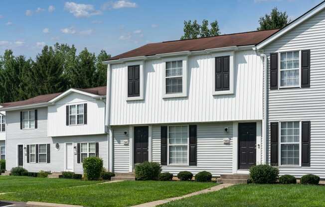 a white house with black shutters and a brown roof