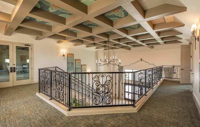 A large room with a balcony and a chandelier.