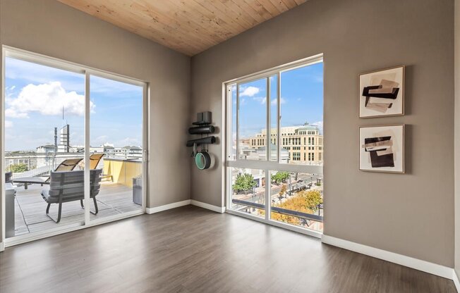 A room with a view of the city through large windows.