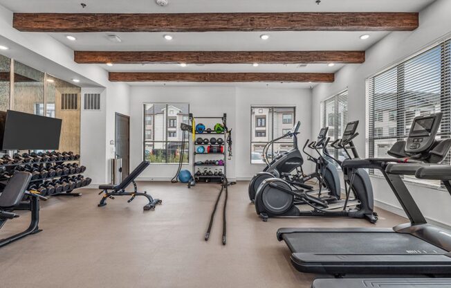 a gym with treadmills and other exercise equipment and windows