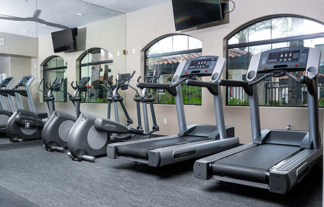 A gym with treadmills and elliptical machines.