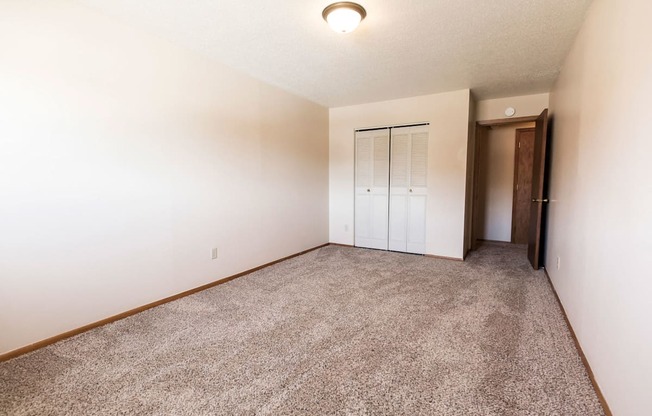 Grand Forks, ND Cherry Creek Apartments. A bedroom with white walls and a carpeted floor