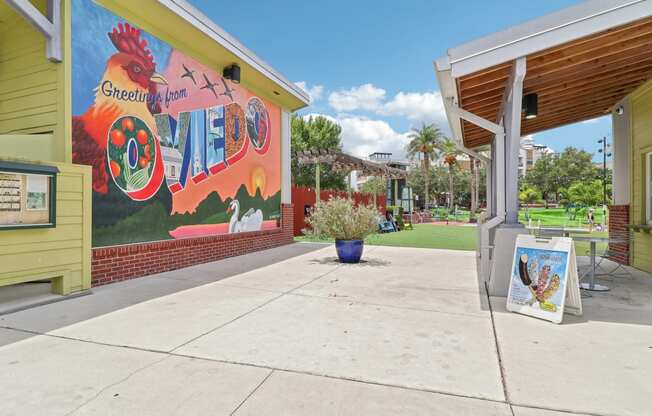 a mural on the side of a building with a sidewalk