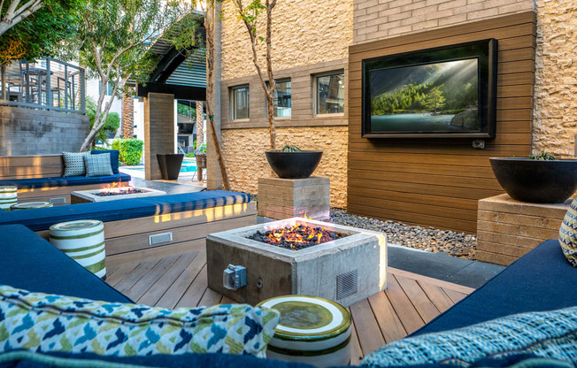 A modern outdoor living space with a fire pit and seating area.