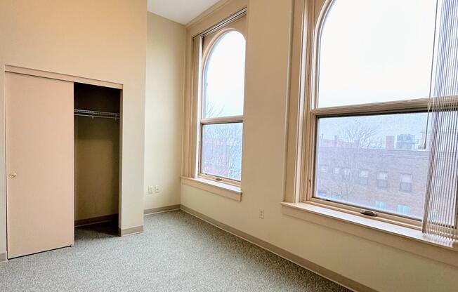 an empty room with large windows and a closet
