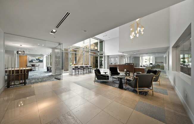 a large lobby with chairs and tables and glass walls