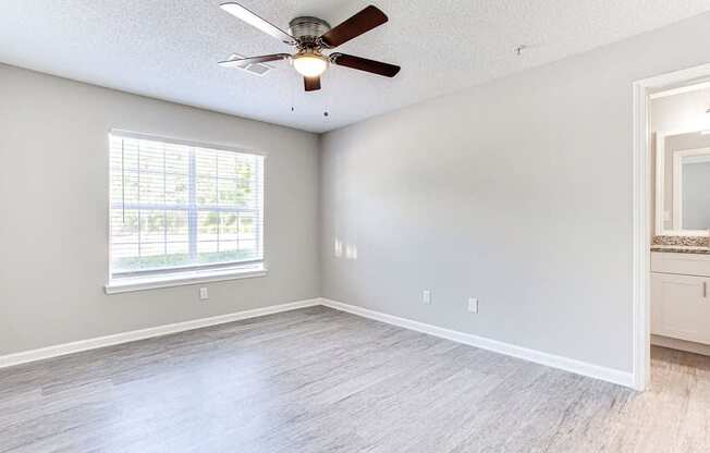 A room with a ceiling fan and a window.
