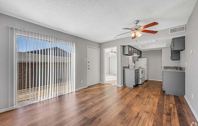 A room with a ceiling fan and wooden floors.