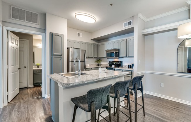 a kitchen with a large island with bar stools