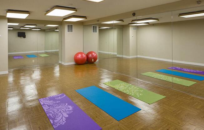 Yoga studio with large mirrors, yoga mats, and exercise balls